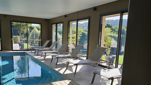 A modern indoor pool area with clear views of the outdoors, including a garden and distant mountains. - La Fraîchette (La Riviere-Saint-Sauveur)