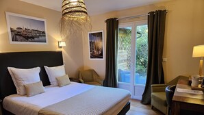A hotel room with a large bed, a chair, a desk, and a view of the outdoors. - La Fraîchette (La Riviere-Saint-Sauveur)