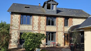 A two-story house with a stone facade, large windows, and a well-maintained lawn with two lounge chairs. - La Fraîchette (La Riviere-Saint-Sauveur)