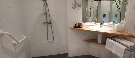 A modern bathroom with a shower, a sink, and a mirror.