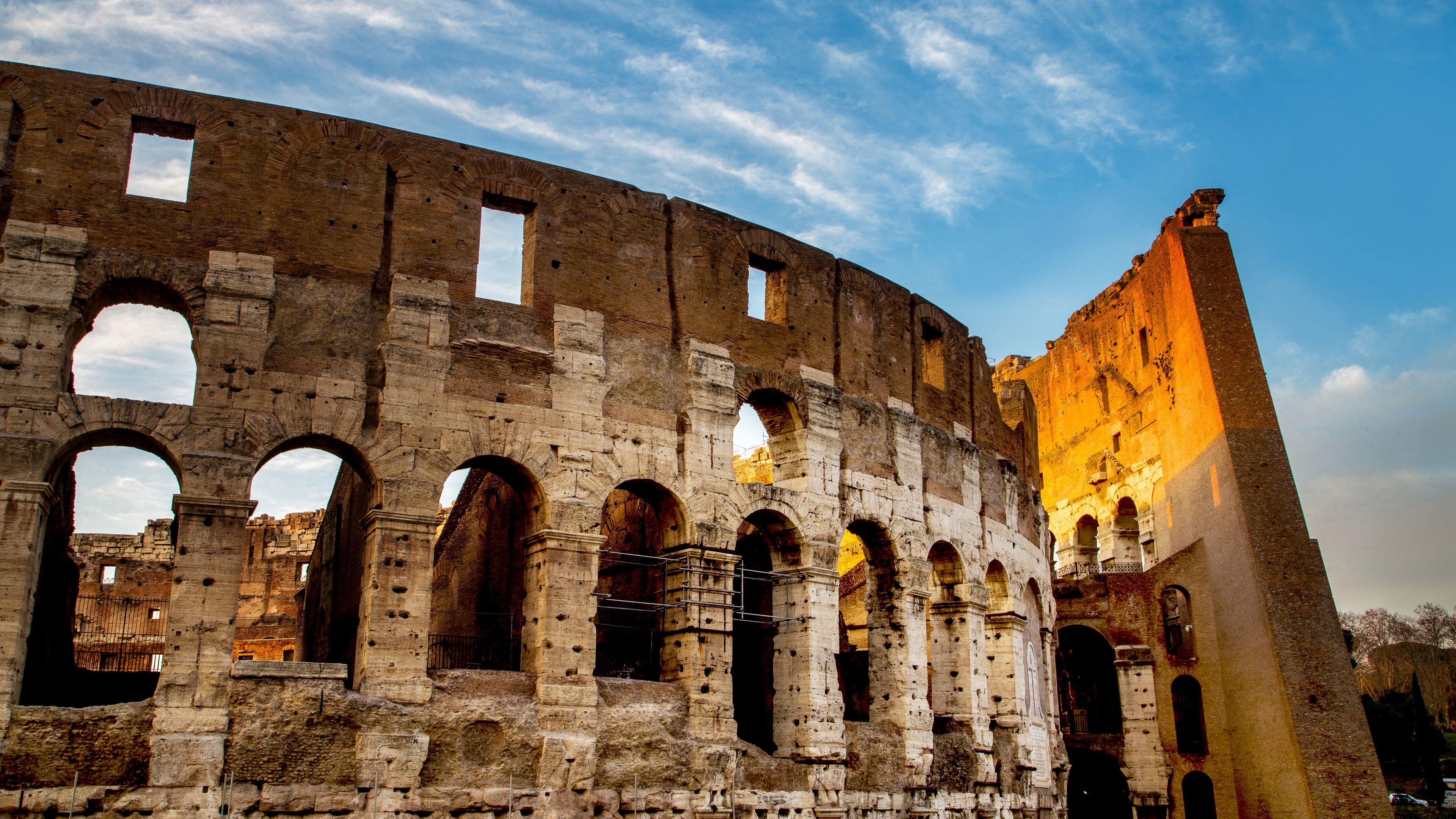 An ancient Roman amphitheater with multiple arches and a partially intact wall.