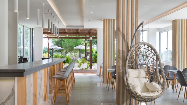 Un interior moderno con una zona de bar, asientos y un sillón colgante.