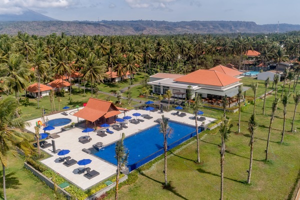 Di pantai, pasir hitam, payung pantai, dan handuk pantai