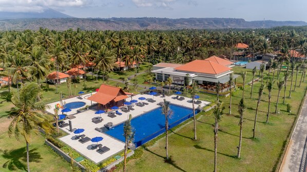 På stranden, sort sand, parasoller og strandhåndklær