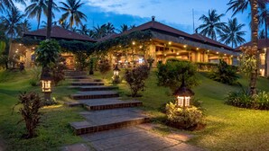 Een resort met een goed verlichte entree, verharde paden en weelderige begroeiing.