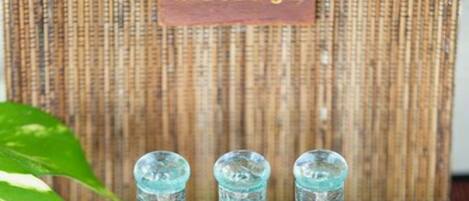 A wooden stand with three glass bottles labeled "Relaxation," "Awake," and "Revive" at The Omaha Massage.