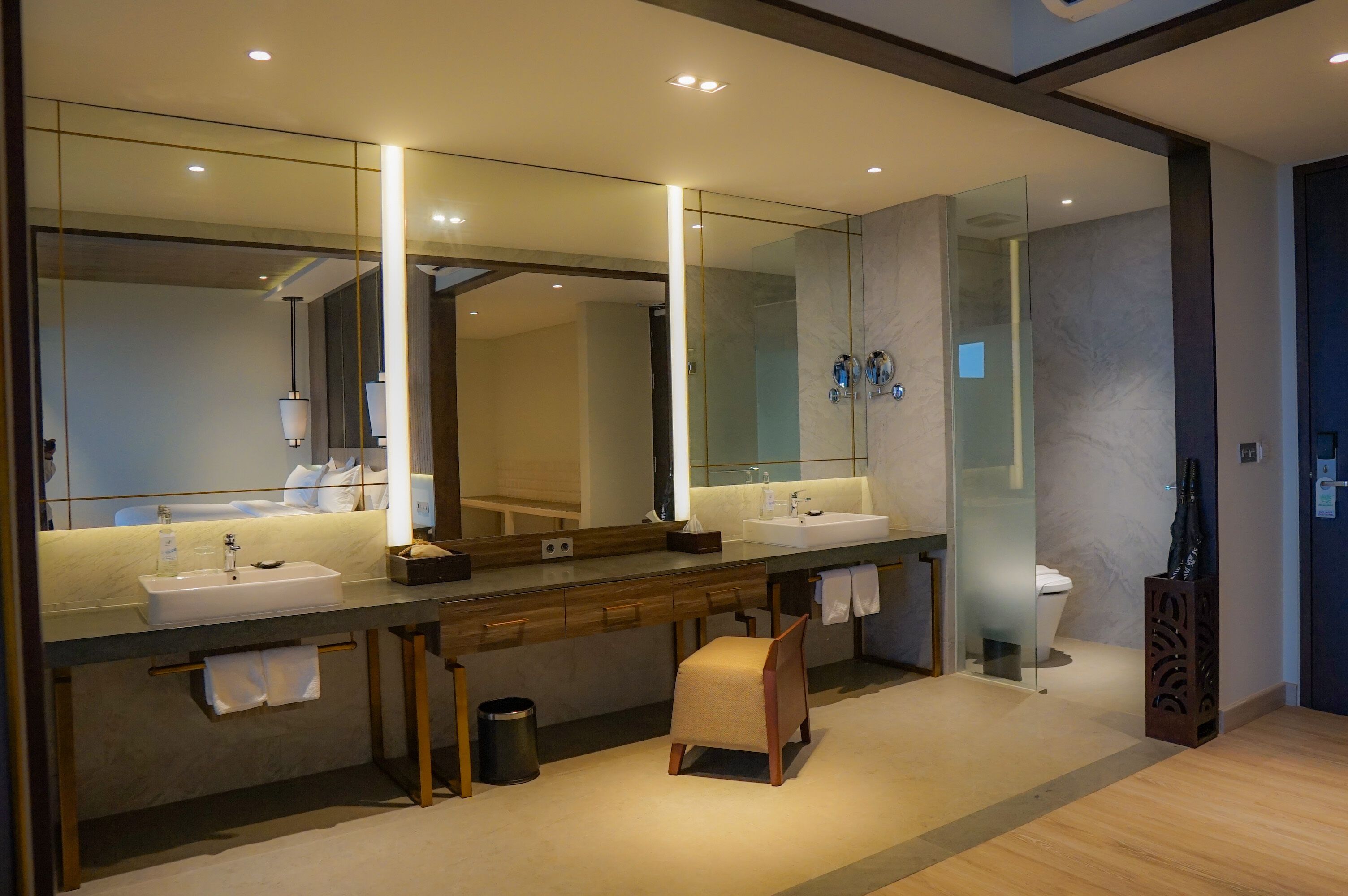 A modern bathroom with two sinks, a large mirror, and a glass shower enclosure.