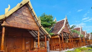 Una hilera de casas tradicionales de madera con tejados de tejas, cercas de madera y un camino de piedra.