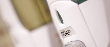 A soap dispenser on a white surface.