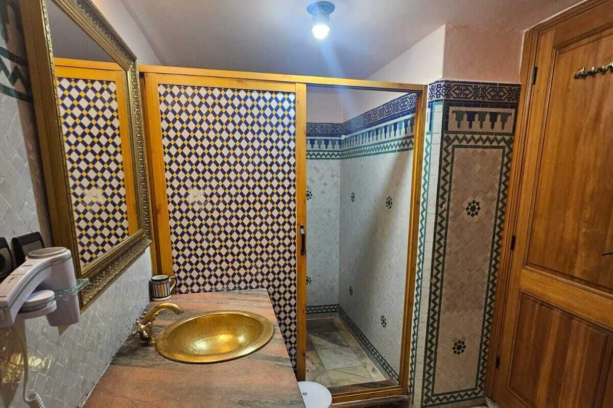 A bathroom with a sink, mirror, and patterned tiles.