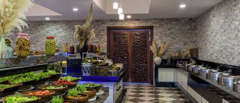 A buffet setup with various food items and a checkered floor pattern.