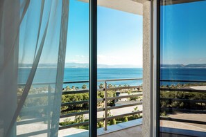 A balcony with a clear view of the sea and distant mountains.