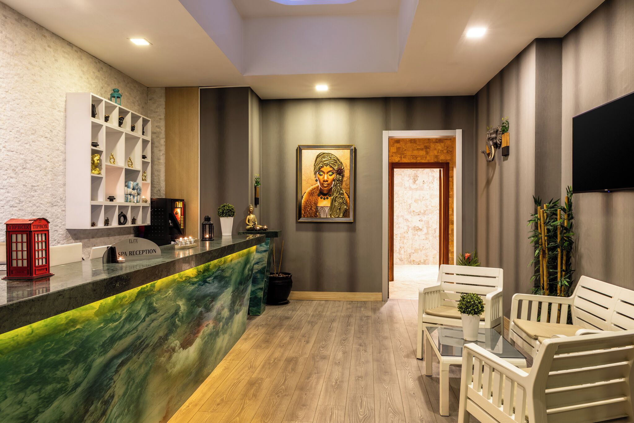 A reception area with a marble counter, a Buddha statue, and a reception desk.