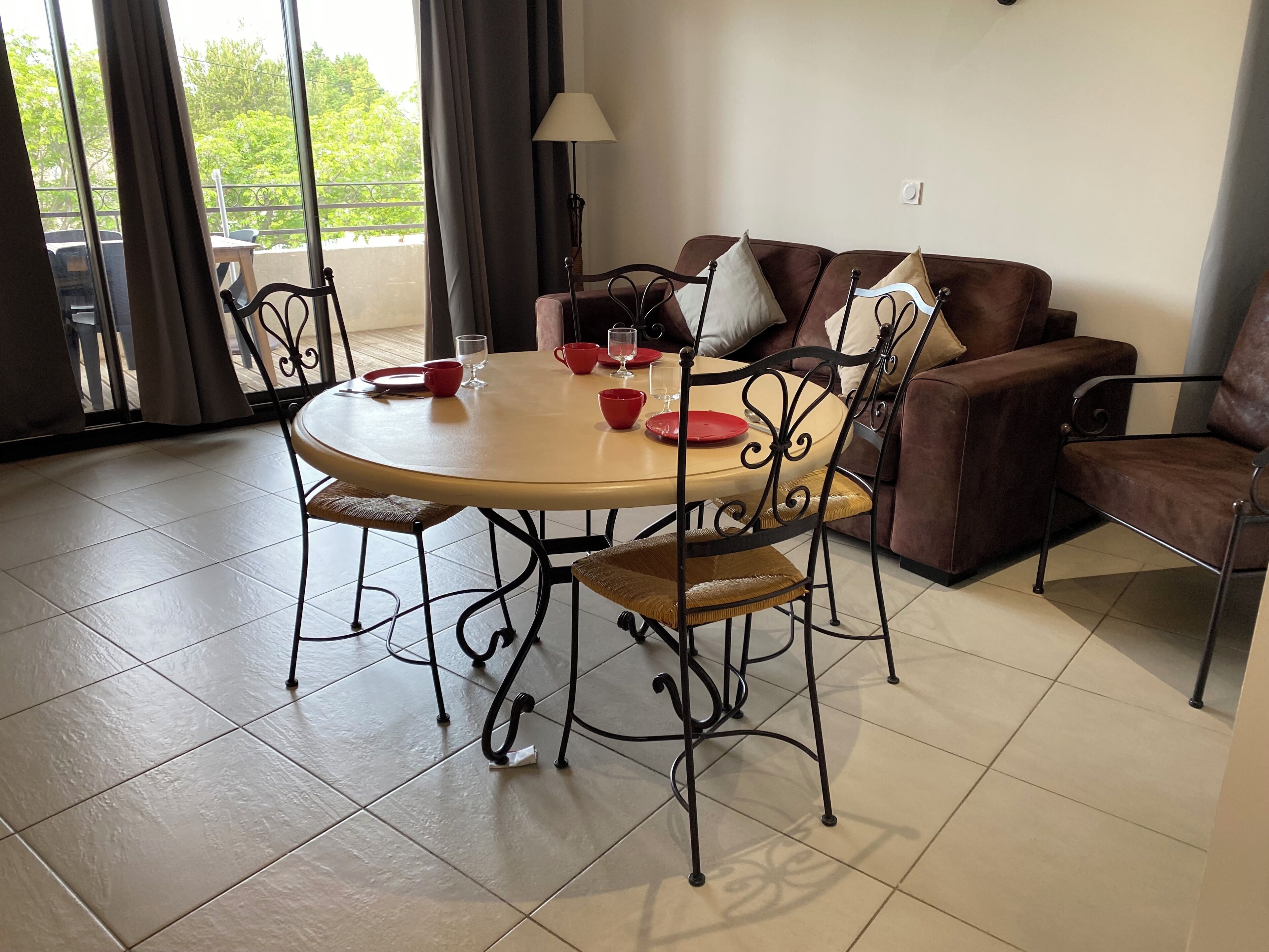 Zona pranzo con tavolo rotondo, sedie e divano.