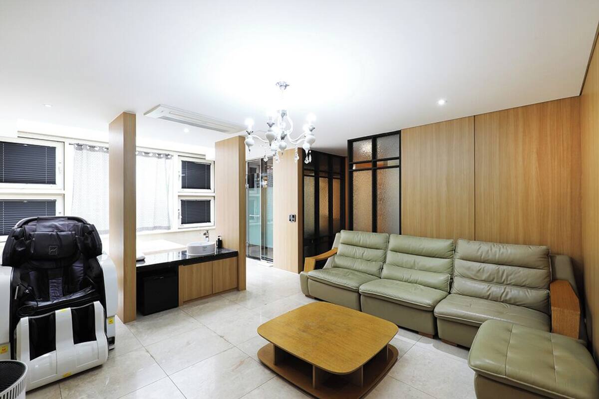Een moderne woonkamer met een bank, een salontafel en een massagestoel.