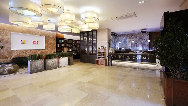 A hotel lobby with a reception desk, bookshelves, and a marble floor. - Sorae Tourist Hotel Cacao (Incheon)