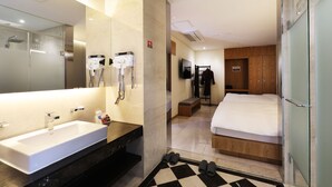 A modern hotel room with a large bathroom sink, a shower, a bed, and a TV. - Sorae Tourist Hotel Cacao (Incheon)