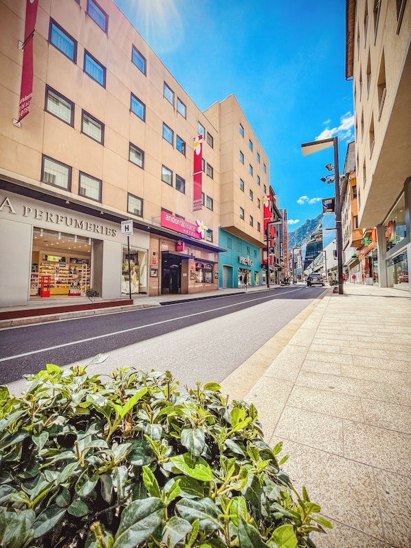Eine Straße mit dem Hotel Andorra Palace Hotel, dem Geschäft Perfumeries und einem Gebäude mit der Aufschrift Prestig.