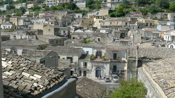 Une ville pittoresque, construite sur une colline, où les maisons sont très rapprochées les unes des autres et présentent une architecture traditionnelle ainsi que des toits en tuiles de terre cuite.