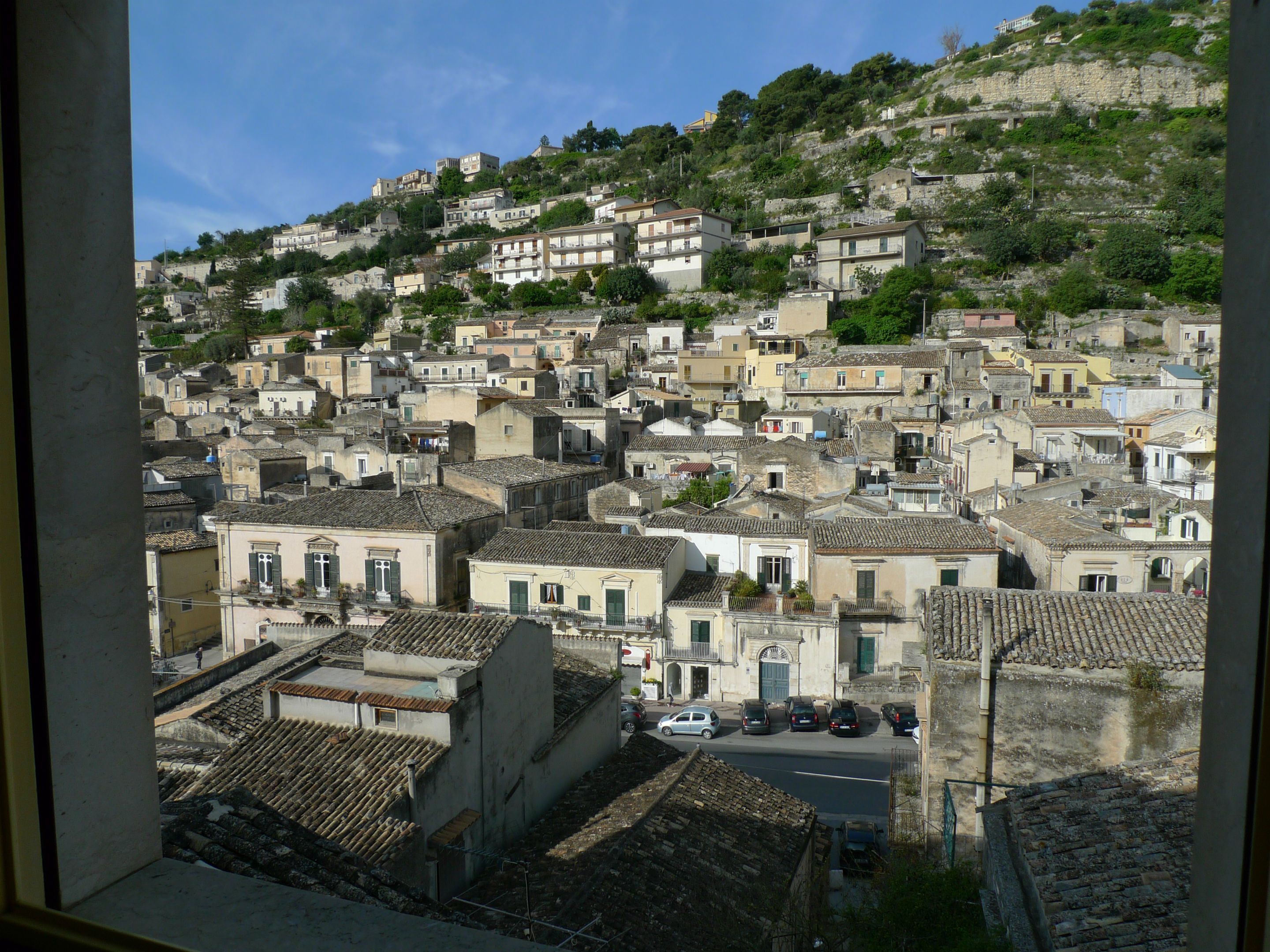 Un pueblo en una ladera con construcciones tradicionales, calles estrechas y una combinación de viviendas.