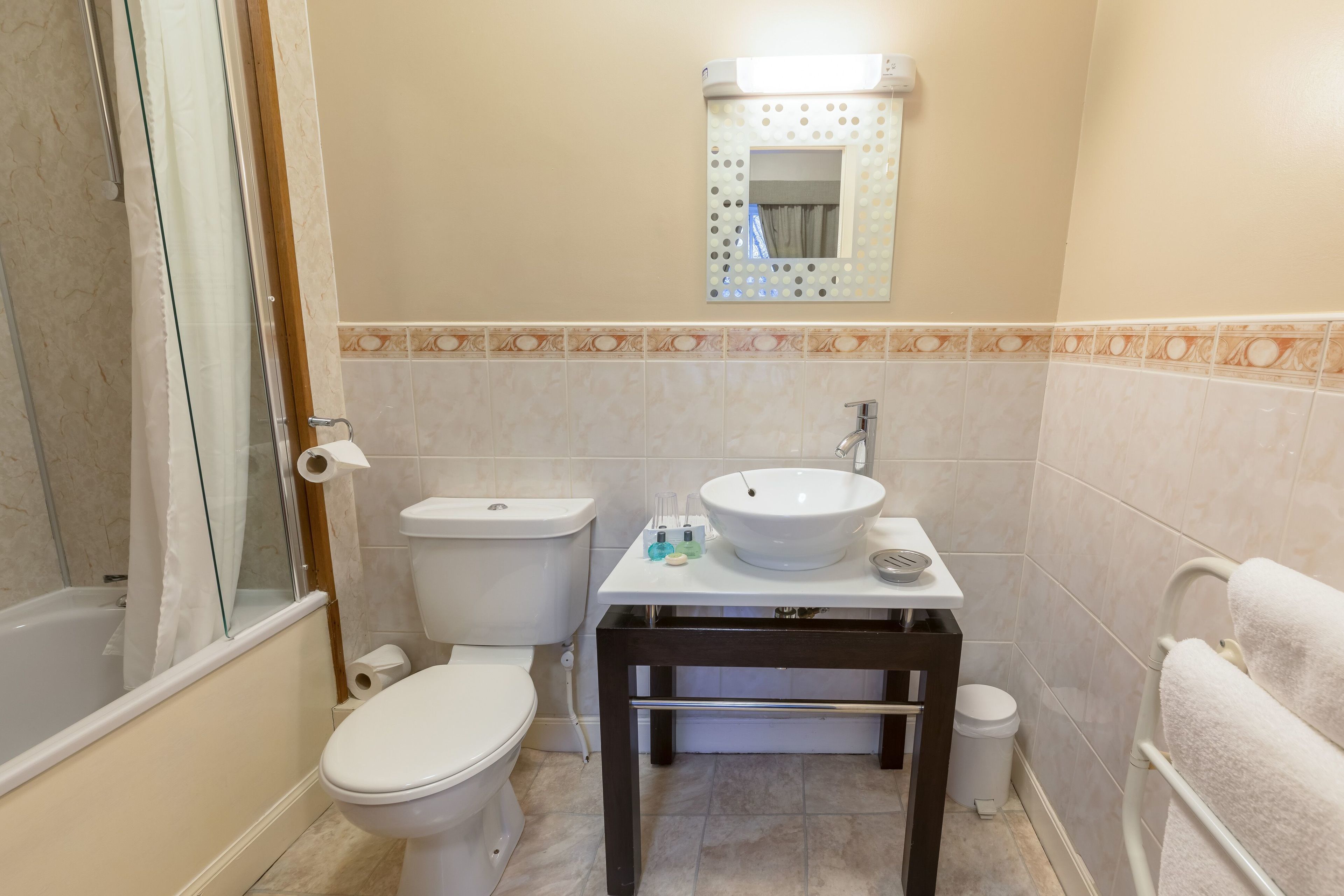 Un baño con inodoro, lavabo y ducha.
