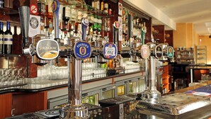 A bar with multiple beer taps, including brands like Strongbow and Foster's.