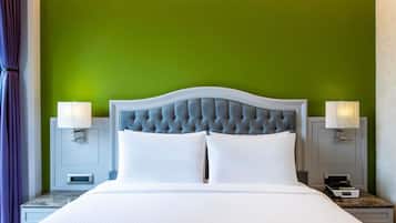 Une chambre d’hôtel avec un grand lit, deux tables de chevet et un mur vert.