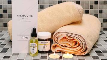 A spa package with towels, candles, and skincare products.