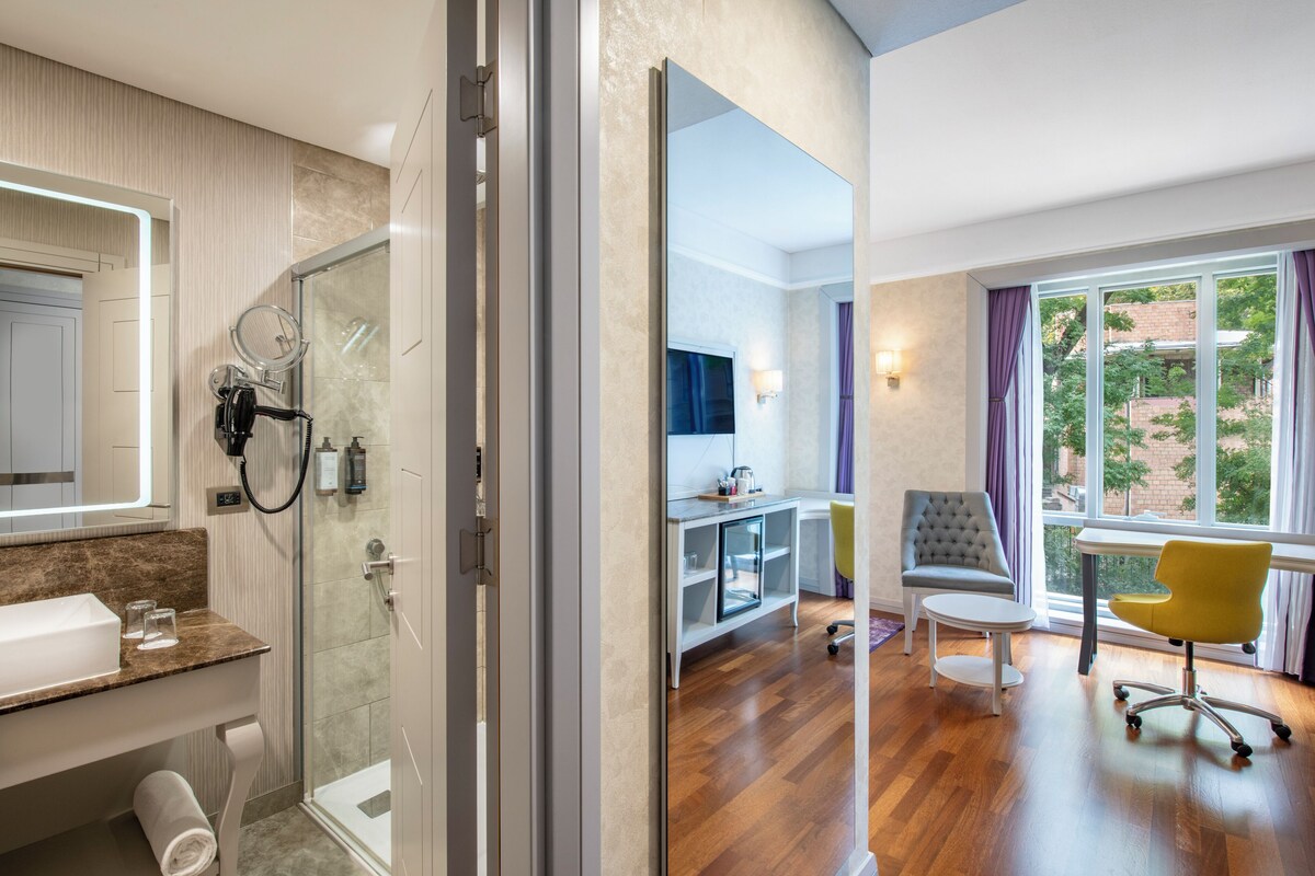 Un baño moderno con ducha de vidrio, tocador con espejo y lavamanos.