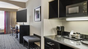 A hotel room with a kitchenette, a flat-screen TV, a desk with a chair, and a bed. - Best Western Plus Laredo Inn & Suites (Laredo)