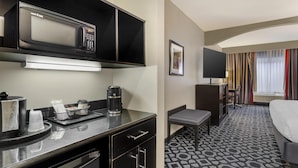 A hotel room with a kitchenette, a bed, a desk, and a window with curtains. - Best Western Plus Laredo Inn & Suites (Laredo)