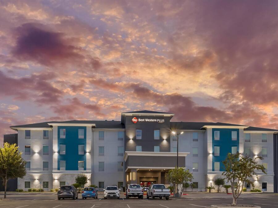 Een Best Western PLUS hotel met een modern design, met meerdere verdiepingen en een parkeerplaats met verschillende voertuigen.
