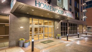 A hotel entrance with a sign reading "Homewood Suites."