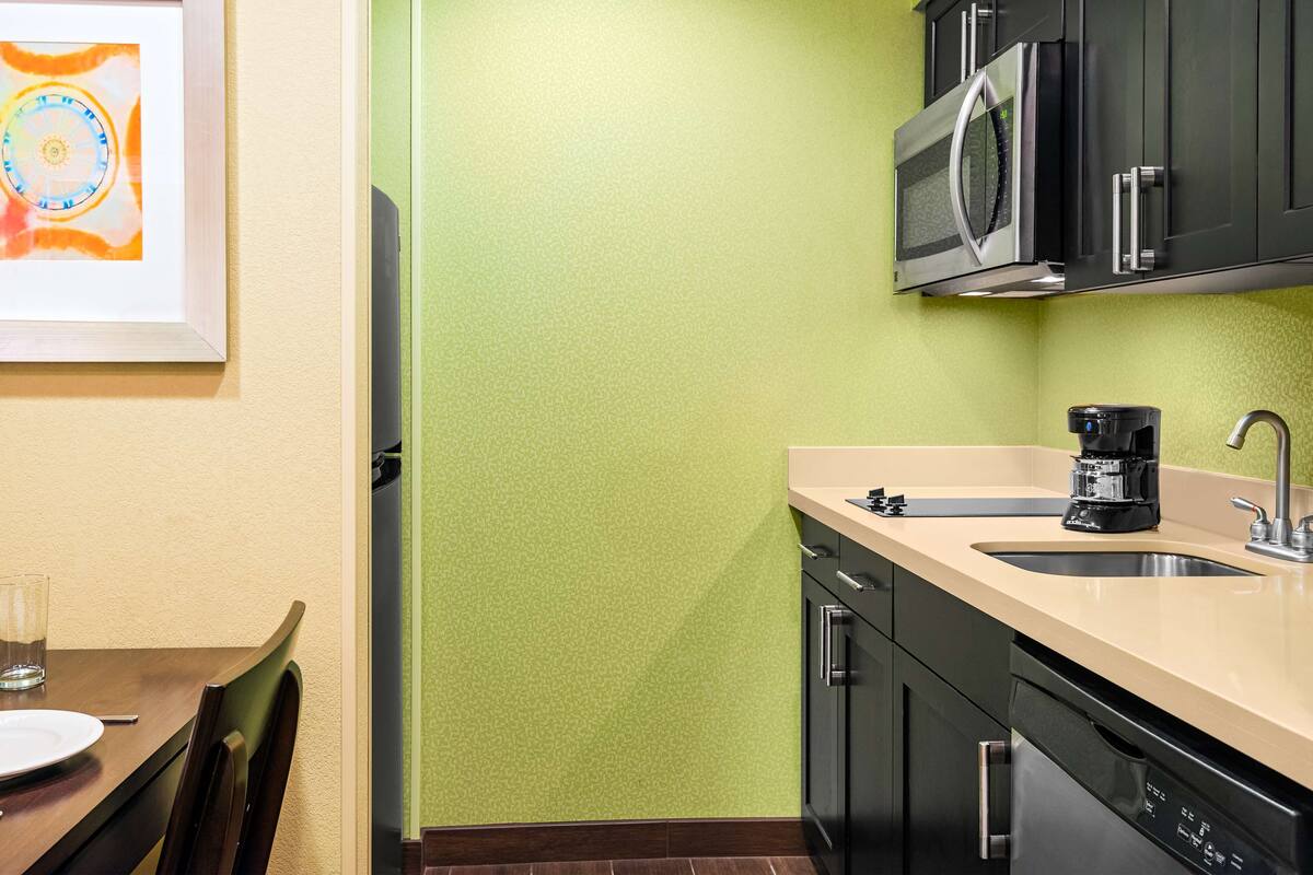 A kitchen with a microwave, coffee maker, and dishwasher.