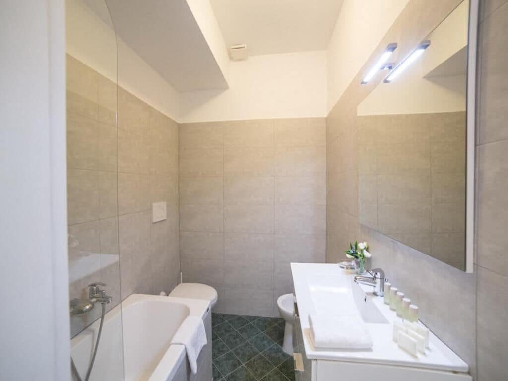 A modern bathroom with a bathtub, toilet, and sink.