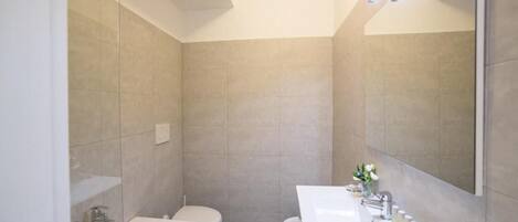 A modern bathroom with a bathtub, toilet, and sink.