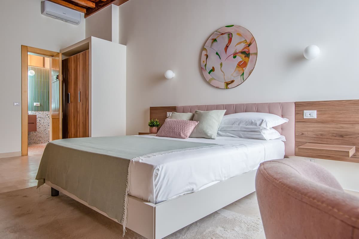 A bedroom with a bed, a round wall decoration, and a wooden headboard.