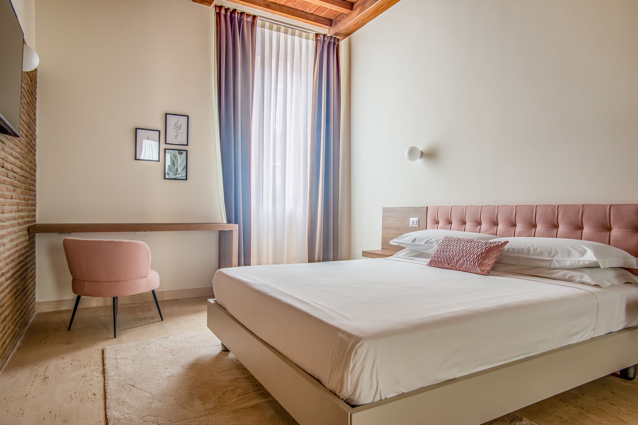 A bedroom with a bed, a desk, and a chair.
