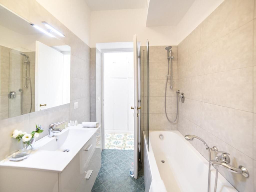 A modern bathroom with a bathtub, a shower, and a sink.