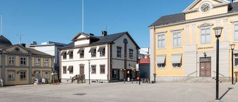 A cobblestone square with historic buildings, including a museum.