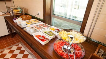 Um buffet com diversos alimentos e utensílios.