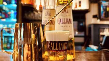 Eine Bar-Szene mit einem mit ‚Galliano Hot Shot‘ beschrifteten Glas und einer Galliano-Flasche.