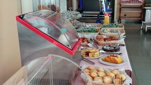 Montaje de bufé con diferentes alimentos y una máquina de café.