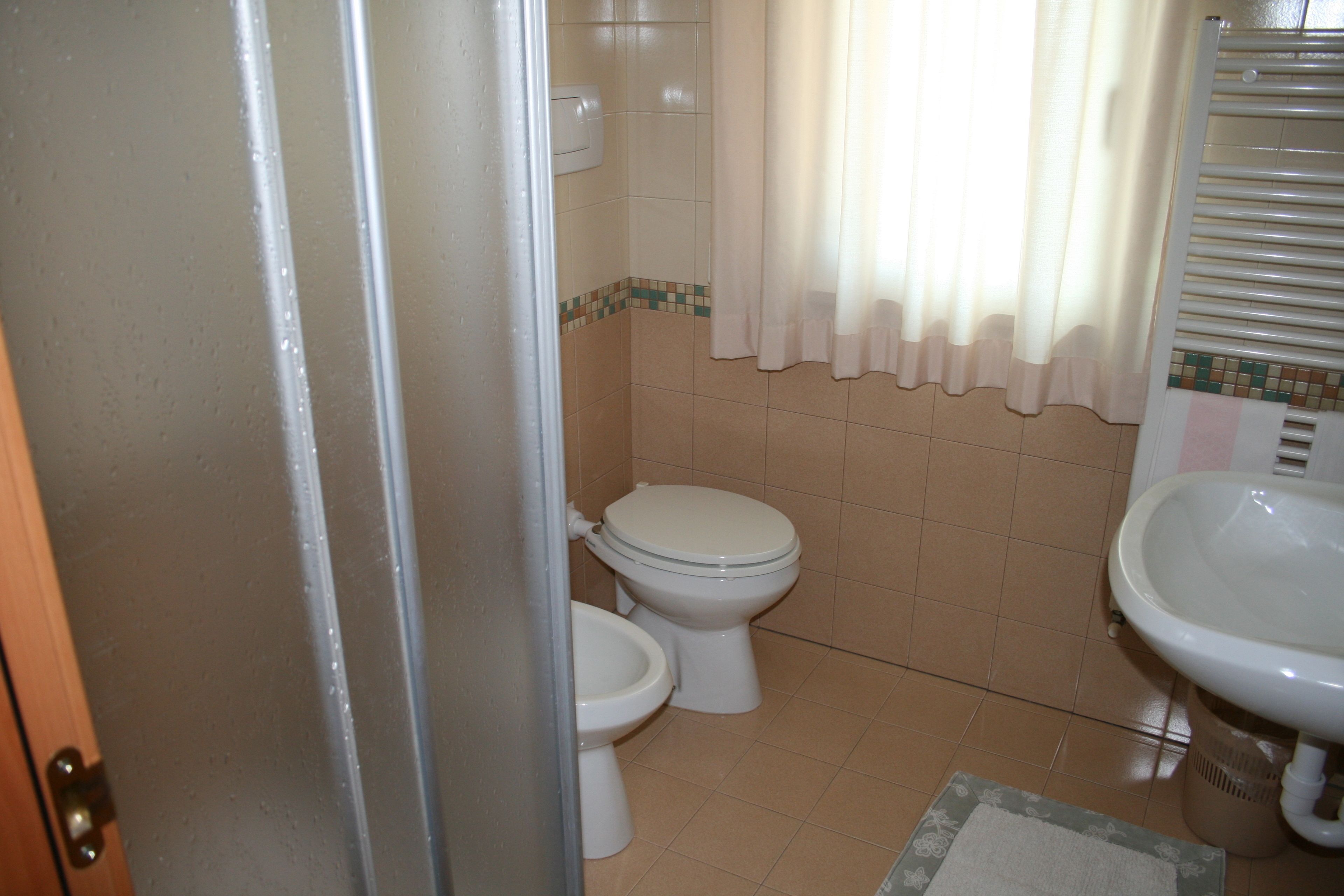Un baño con inodoro, bidé y lavamanos.