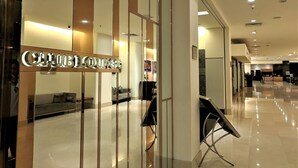 En moderne hotellobby med reception, siddeområde og et skilt der siger "City Lounge".