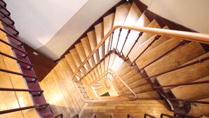 A wooden spiral staircase with a metal handrail and wooden steps. - Hôtel des Pyrénées (Paris)