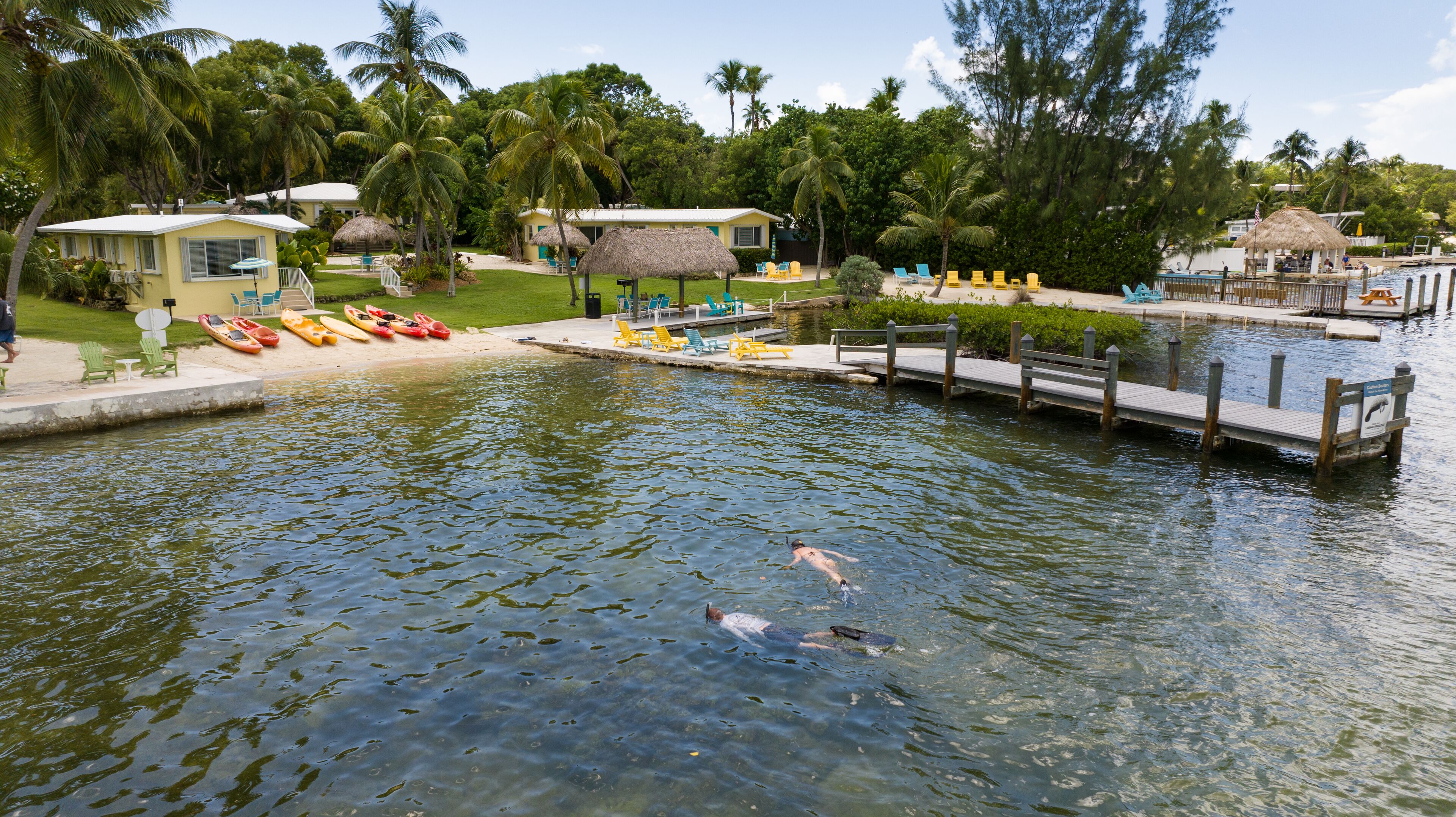 Area piscina con kayak, sdraio e molo.