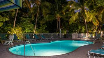 Een buitenzwembad, parasols bij het zwembad en ligstoelen