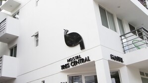 A modern building with a white facade, a large black peacock logo, and the name "Hostal Central" on the front. - Hostal Tres Central (Tuxtla Gutierrez)