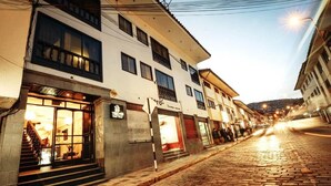 Rua com edifícios, uma placa e uma escadaria que leva a uma loja.